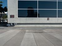 an empty parking lot and a sign near a building with many windows on it and a fire hydrant sitting outside