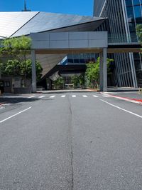 a street with no traffic or pedestrians on it in front of a high rise building