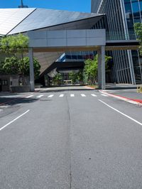 a street with no traffic or pedestrians on it in front of a high rise building