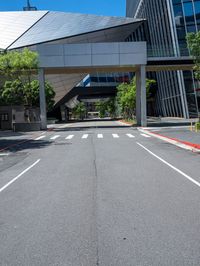 a street with no traffic or pedestrians on it in front of a high rise building