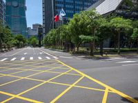 a view of a city street with a flag flying at the top of it and yellow lines on the road