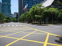 a view of a city street with a flag flying at the top of it and yellow lines on the road