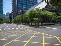 a view of a city street with a flag flying at the top of it and yellow lines on the road