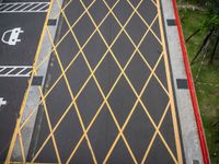 a cross - painted yellow line is on an empty parking lot outside a building in a residential neighborhood