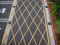 a cross - painted yellow line is on an empty parking lot outside a building in a residential neighborhood