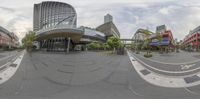 the spherical view of a big building near many tall buildings with a small walkway between them