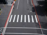 a view of a crosswalk and a road in an urban area with the traffic lights