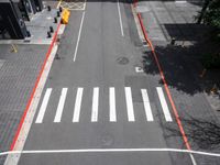 a view of a crosswalk and a road in an urban area with the traffic lights