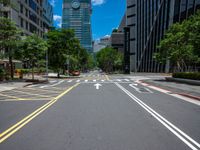 a wide road with buildings and trees in the middle of the road in front of it