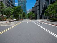 a wide road with buildings and trees in the middle of the road in front of it