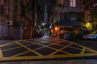 a person is walking down a dark city street with traffic lights at night on one side of the road