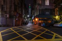 a person is walking down a dark city street with traffic lights at night on one side of the road