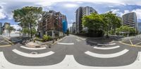 an intersection with a street that has a car driving in it, and the buildings behind it