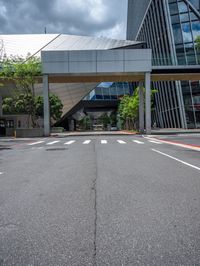 the street is empty near the glassy building on which two street lights stand on either side