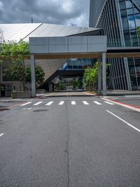 the street is empty near the glassy building on which two street lights stand on either side