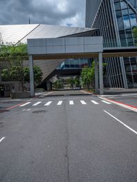 the street is empty near the glassy building on which two street lights stand on either side