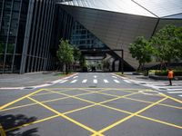 a road in front of a modern building with a few trees on it at the sides of the road