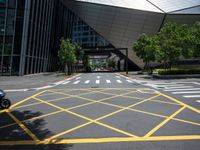 a road in front of a modern building with a few trees on it at the sides of the road