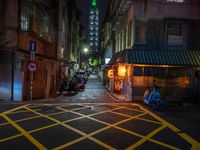 an alley with an umbrella, parked motorcycles and the oriental architecture at night - - a woman sits alone in the dark