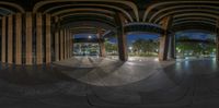 an outdoor skate park with lots of arches and arches and benches in the distance, in the foreground is a fountain