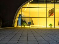 a building with a giant door next to it at night and outside on an empty surface