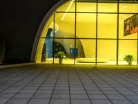 a building with a giant door next to it at night and outside on an empty surface