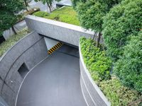 a parking space with concrete walls and green foliages on top of the roof,