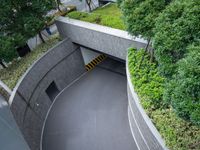 a parking space with concrete walls and green foliages on top of the roof,