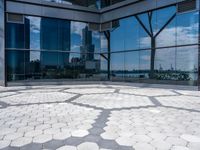 a room with hexagonal floor tiles in front of large windows with a view of a city in the background