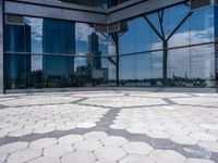 a room with hexagonal floor tiles in front of large windows with a view of a city in the background