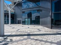 a view of an empty courtyard in front of a building with windows on a sunny day