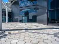 a view of an empty courtyard in front of a building with windows on a sunny day