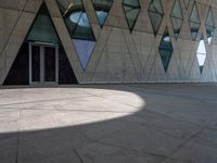 there is a large glass building with many windows and a large stone walkway outside it