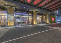 the outside of a building with some glass doors in it's front area at night