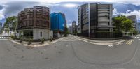 360 view of an intersection in a city setting with buildings on either side, on a cloudy day