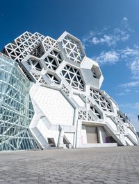 a building with geometric architectural design and glass in the front corner on a clear day