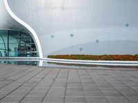 there is an open space next to the building, with colorful flowers in the background