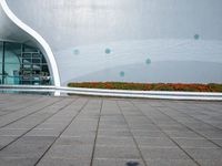 there is an open space next to the building, with colorful flowers in the background