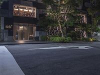 a car parked on the side of a road at night in front of a building