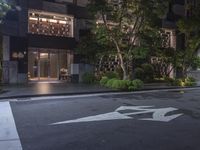 a car parked on the side of a road at night in front of a building