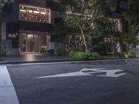 a car parked on the side of a road at night in front of a building