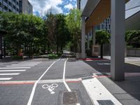 bike lanes and markings on the sidewalk in a city setting that has some buildings near it