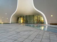 an empty pool that is near the entrance to an office building with an arched roof