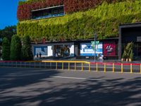 an empty parking lot with trees and shrubs on the wall that resemble a moss growing over it