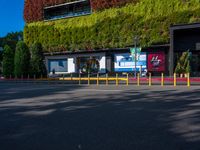 an empty parking lot with trees and shrubs on the wall that resemble a moss growing over it