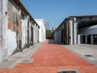 a narrow brick road leading into an old building structure in the city area of miami