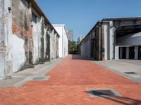 a narrow brick road leading into an old building structure in the city area of miami