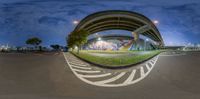 fisheye lens view of street and road with graffiti on wall and road markings along side