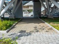 a walkway that is built inside a building surrounded by greenery and flowers on the street