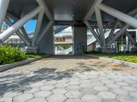 a walkway that is built inside a building surrounded by greenery and flowers on the street